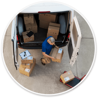 A courier loading the packed painting into a delivery van